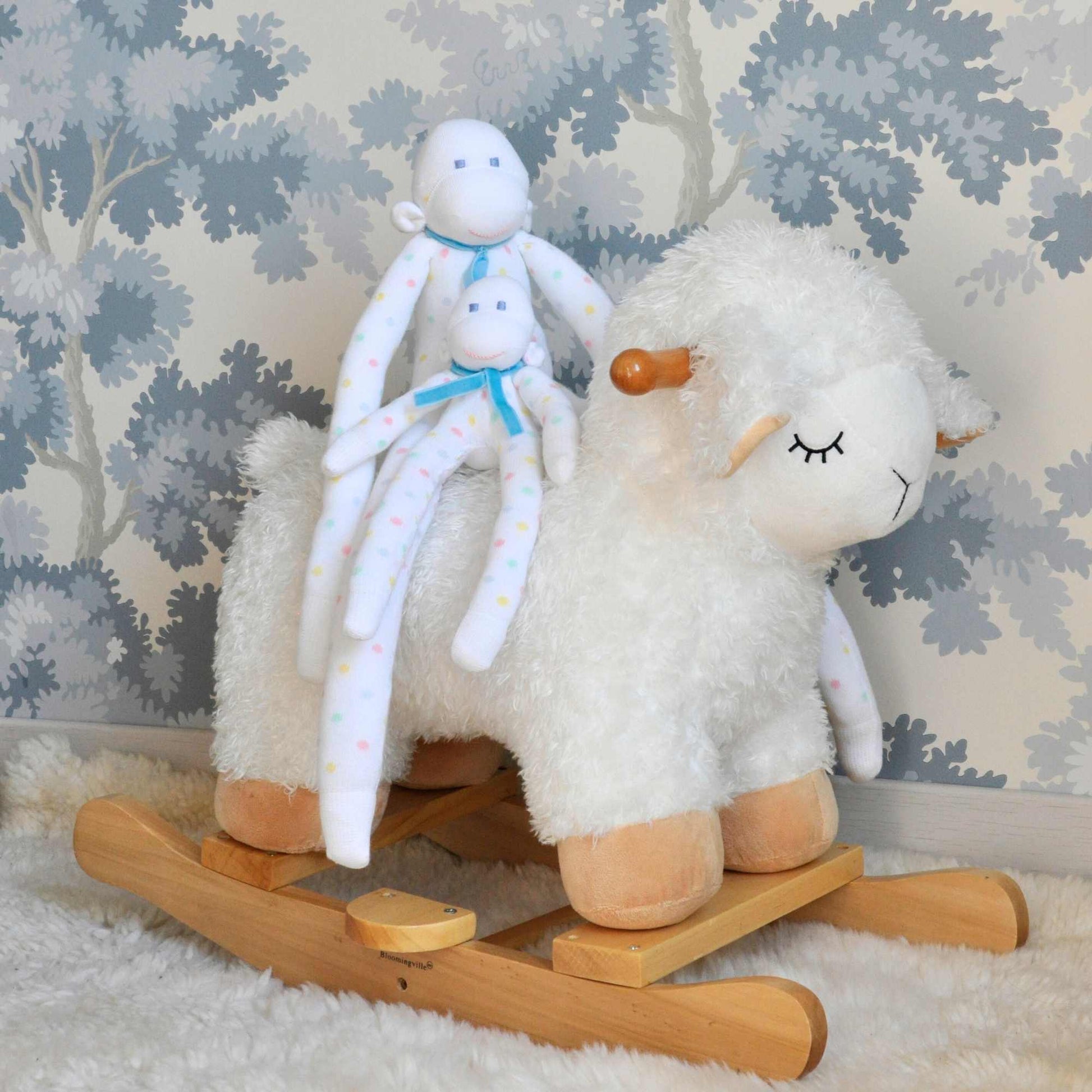 grand et petit doudous leon ensemble sur un mouton à bascule dans une chambre bleue