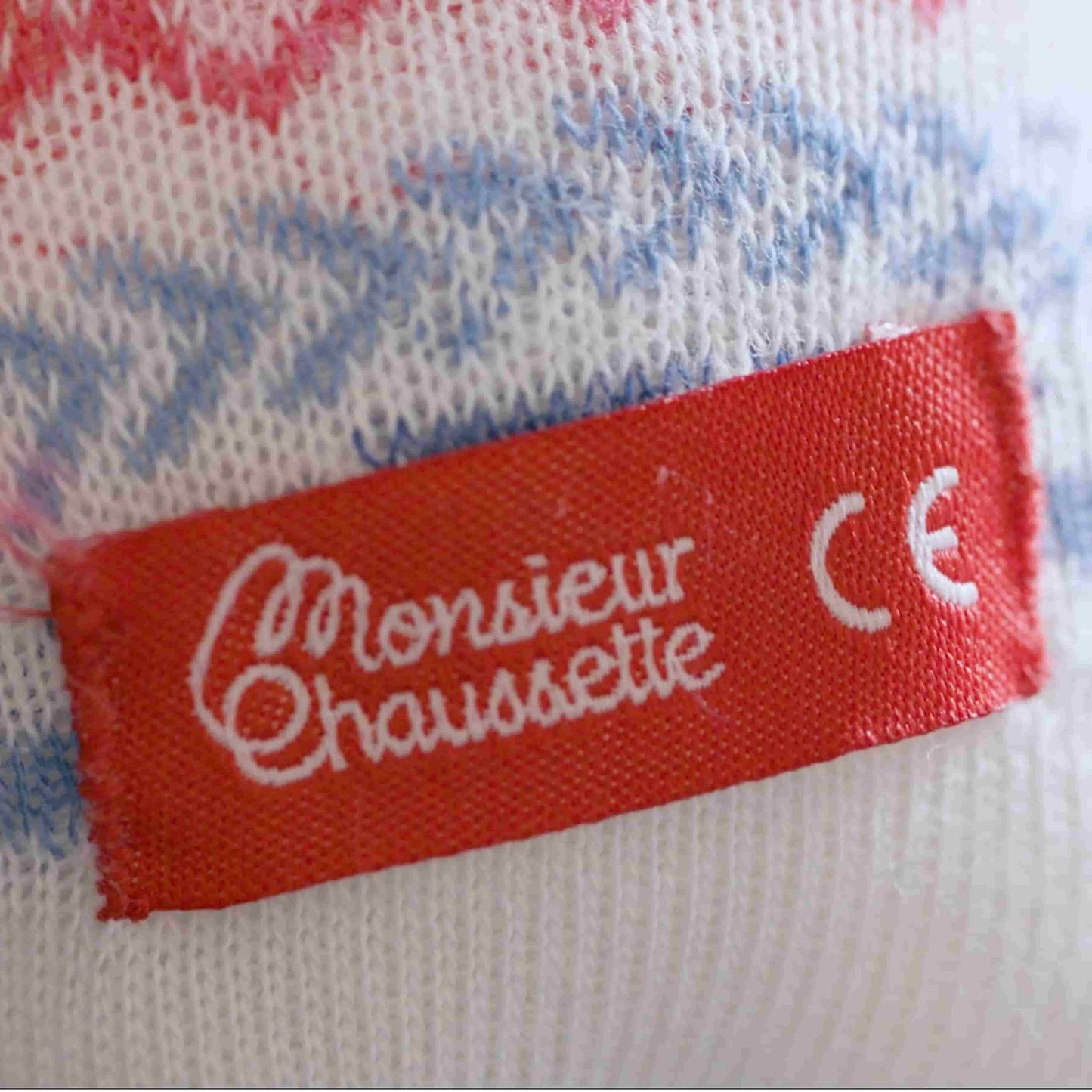 Gros plan sur l'étiquette MOnsieur Chaussette rouge qui comporte la mention CE "conformité européenne"